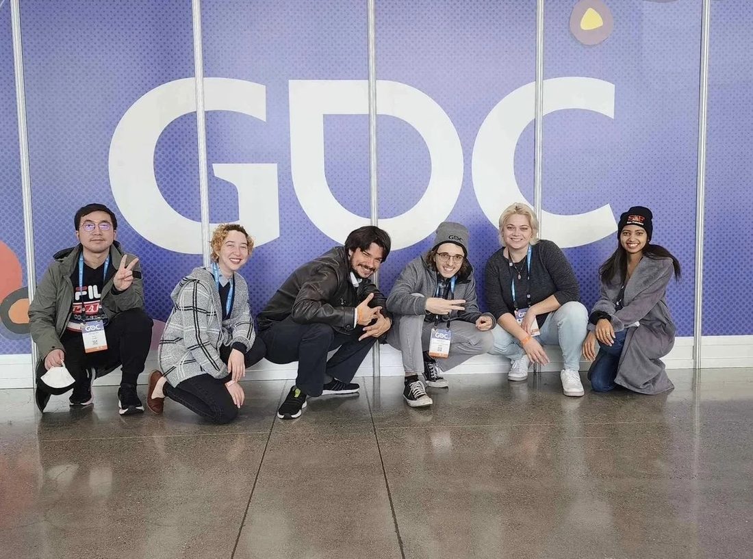 A group of developers at GDC in front of the GDC sign.